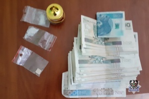 banknoty i narkotyki w woreczkach na stole