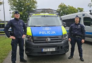 dwaj policjanci przy radiowozie