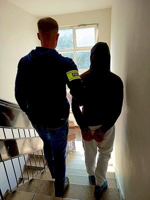 Policjant prowadzi zatrzymanego