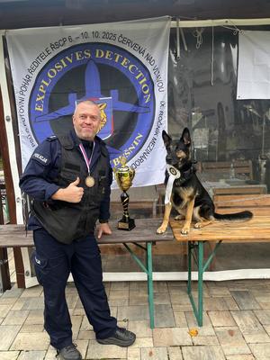 policjant z psem obok puchar