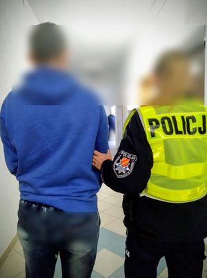 policjant prowadzi zatrzymanego