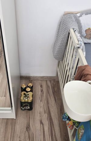 dziecięce łóżeczko w pokoiku z na podłodze puszki piwa