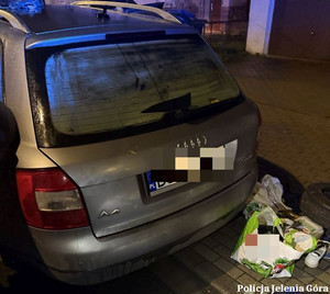 tył samochodu osobowego i rzeczy z bagażnika leżące na ziemi