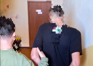 policjant w cywilu prowadzi zatrzymanego mężczyznę