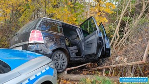 radiowóz za samochodem osobowym po kolizji z drzewem