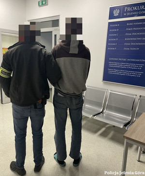 policjant prowadzi zatrzymanego