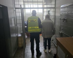 policjant prowadzi zatrzymanego