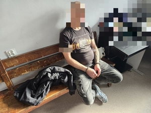 zatrzymany w kajdankach siedzi na ławce