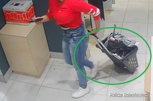 zdjęcie z kamery przemysłowej w sklepie przedstawiające kobietę ciągnącą za sobą wózek sklepowy pełen ubrań