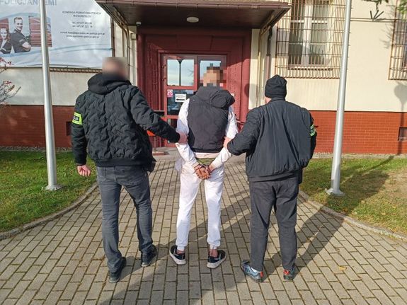 dwaj policjanci prowadzą zatrzymanego