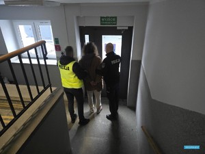 dwaj policjanci wyprowadzają zatrzymaną