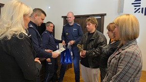 zastępca komendanta wojewódzkiego policji we Wrocławiu wręcza dyplom młodemu mężczyźnie