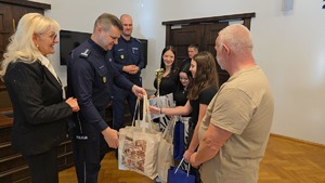 zastępca komendanta wojewódzkiego policji wręcza suweniry dziewczynce
