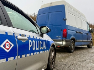 bus niebiesko biały i za nim radiowóz