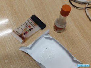 narkotyki w postaci kryształków na kartce obok pozytywny tester narkotykowy