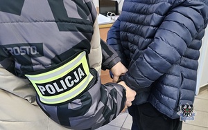 policjanci prowadzą zatrzymanego