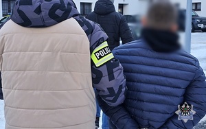 policjanci prowadzą zatrzymanego