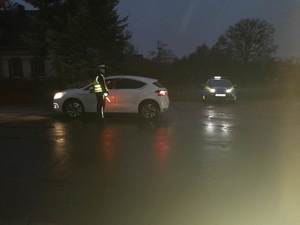 policjant przy zatrzymany samochodzie osobowym obok radiowóz