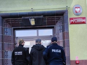 dwaj policjanci prowadzą zatrzymanego