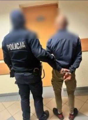 policjant prowadzi zatrzymanego