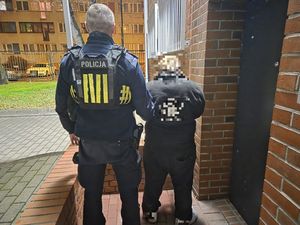 policjant prowadzi zatrzymanego