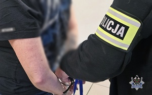 policjant zakłada kajdanki zatrzymanemu