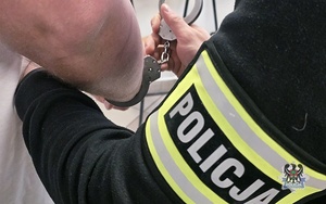 policjant zakłada kajdanki