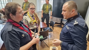 harcerze przekazują policjantowi Betlejemskie Światełko Pokoju