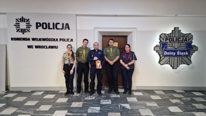 harcerze przekazują policjantowi Betlejemskie Światełko Pokoju