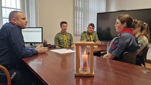 harcerze przekazują policjantowi Betlejemskie Światełko Pokoju