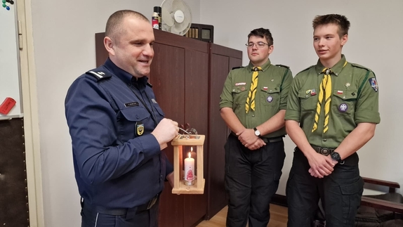 harcerze przekazują policjantowi Betlejemskie Światełko Pokoju