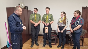 harcerze przekazują policjantowi Betlejemskie Światełko Pokoju