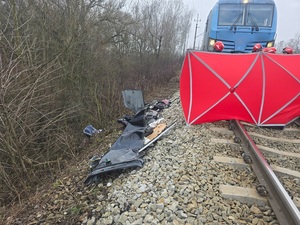 policjanci w oznakowanych mundurach stoją przy torach kolejowych