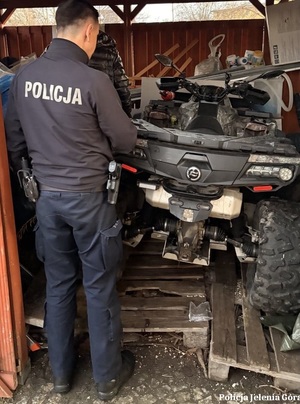 policjant stojący przy quadzie