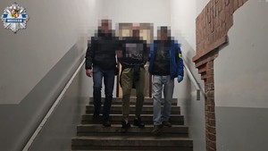 policjanci prowadzą zatrzymanego