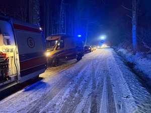 ośnieżona droga karetki i inne pojazdy służb na poboczu