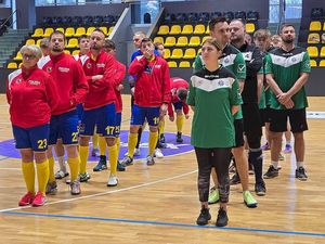 członkowie dwóch drużyn stoją jeden za drugim w dwóch kolumnach