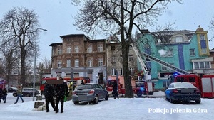 pożar budynku obok którego stoją służby w tym także straż pożarna