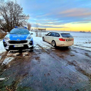 radiowóz na ulicy obok zatrzymany samochód osobowy