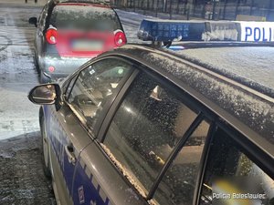 radiowóz na pierwszym plane dalej zatrzymany samochód osobowy