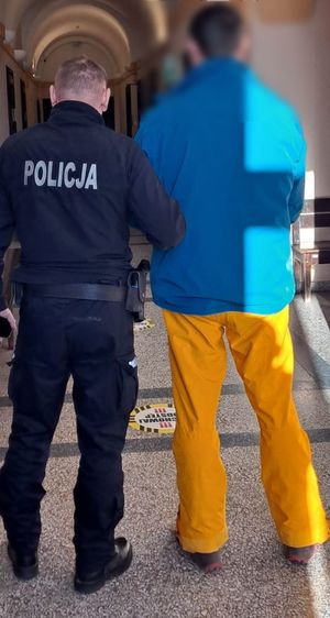 policjant z zatrzymanym mężczyzną