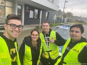 czworo młodych ludzi w kamizelkach odblaskowych z napisem policja