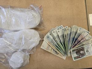 narkotyki (biały proszek) w woreczkach i rozłożone na stole banknoty