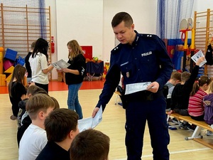 uczniowie spotykają się w szkole z policjantami na pogadance