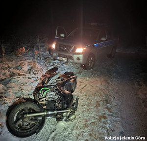 radiowóz i motor leżący na śniegu - zdjęcie od przodu