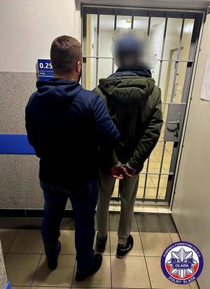 policjant prowadzi zatrzymanego