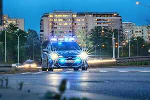 Radiowóz jedzie po asfaltowej jezdni