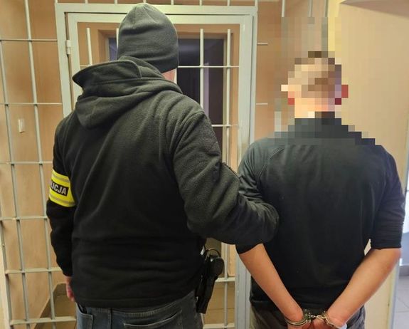 policjant stoi z zatrzymanym mężczyzną