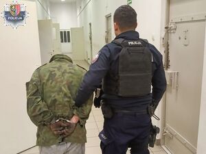 Policjant prowadzi zatrzymanego
