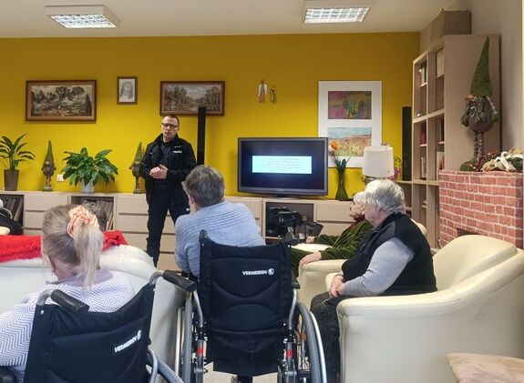 policjant mówi to starszych osób siedzących na wózkach inwalidzkich